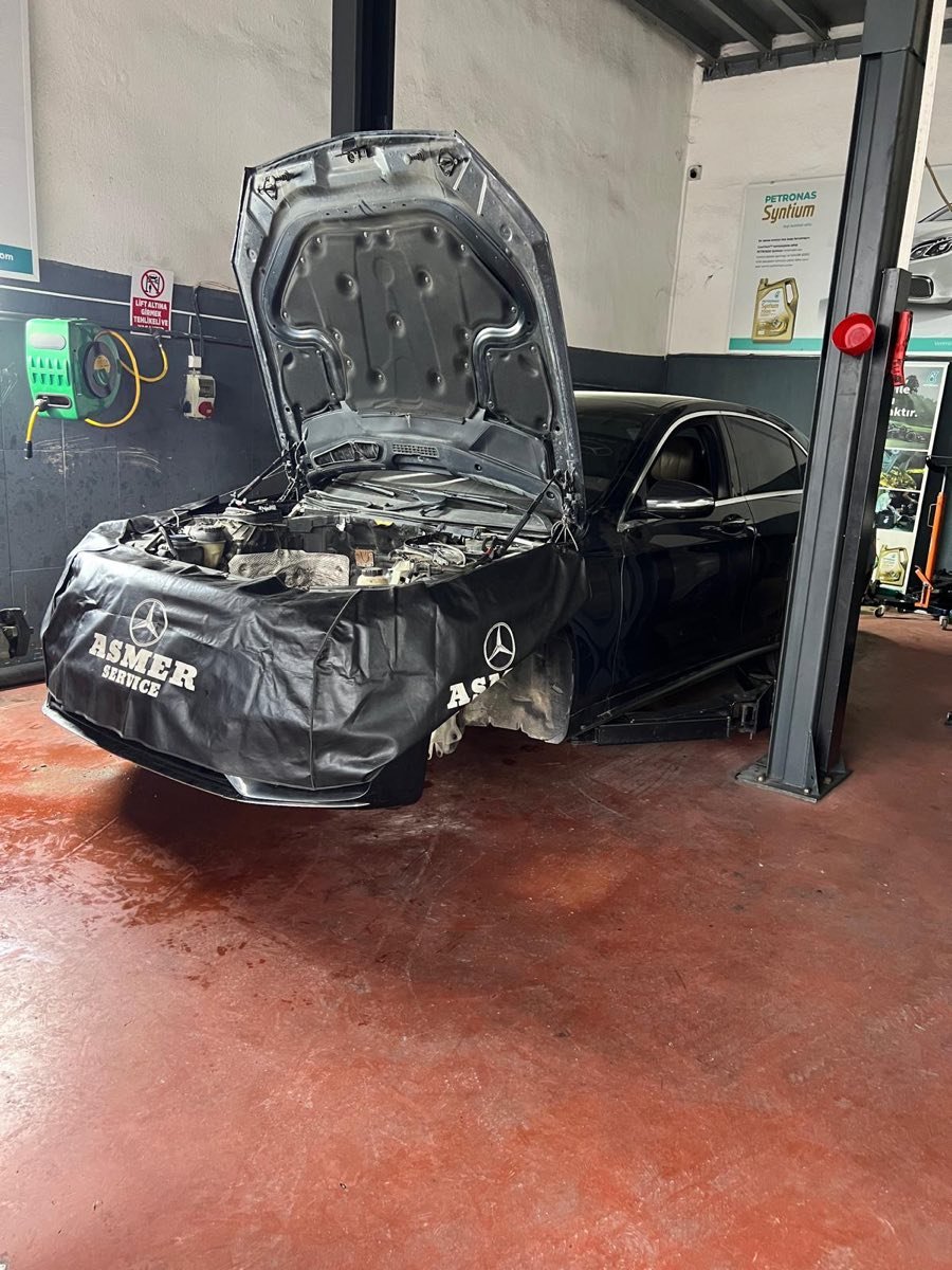 Asmer Service örtüsü serilmiş kaputu açık siyah Mercedes üzerinde motor revizyonu ve bakım işlemi Gölcük